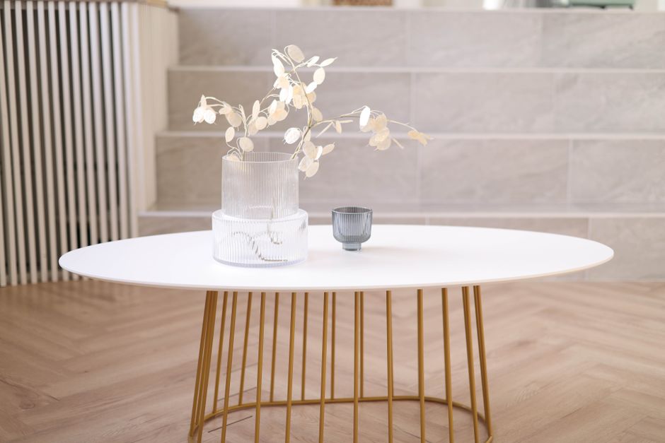 Een stijlvolle ovale houten salontafel in een moderne woonkamer, die ruimte en elegantie toevoegt aan het interieur.
